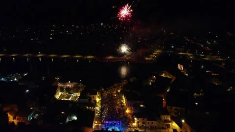 Fireworks exploding over a town celebration at night Stock Footage 339777894