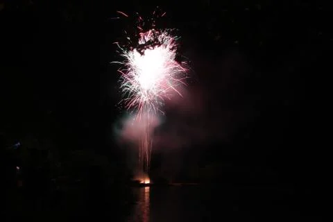 Fireworks exploding in the skies, reflections in the water Foto stock