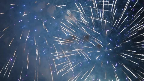 Fireworks exploding in slow motion with vibrant colors and glowing sparks Video stock 303881734