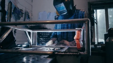 Fireworks fly from welding torch in garage man welding Видео 104077286