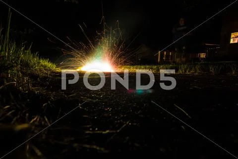 Fireworks glow on sidewalk, night Stock Photos