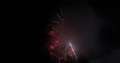 Fireworks going off over black night sky Stock Footage 78887906