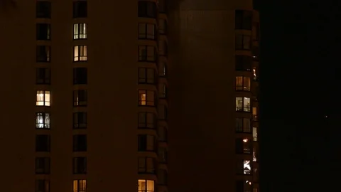 Fireworks reflection viewed on side of apartment building with windows Stock Footage 101222471