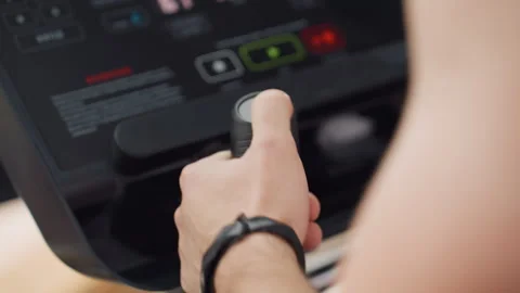 Firm Grip Presses Control Knob On Elliptical Console In Modern Gym Stock Footage 307712741