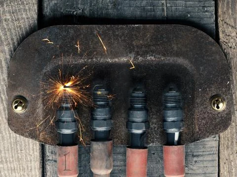 First Advent background with four spark plugs on rusty sign, car workshop adv Stock Photos