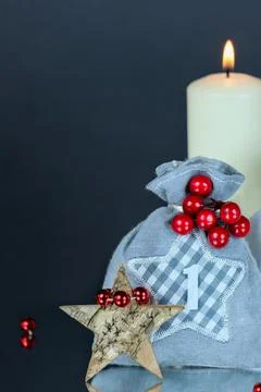 First Advent gift sack number 1,tree bark star,red decor balls,candle,copy space Stock Photos