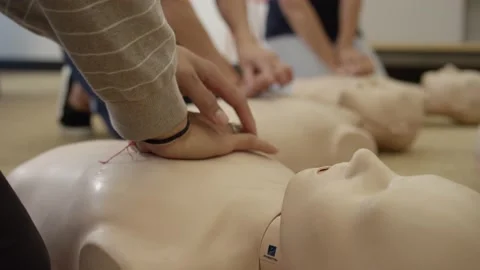 First aid certification training class practicing chest compression on dummy Stock Footage 168654055
