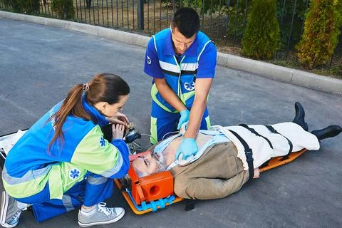 First aid, CPR by rescue workers. Two paramedics performing CPR with mobile d Stockfoto's
