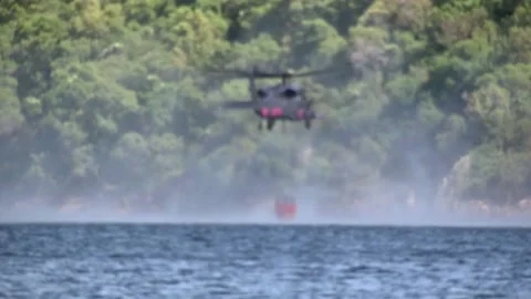 First Aid Helicopter Pick up and Pouring Water Over Forest Stock Footage 130588235