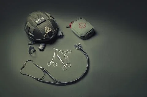 First aid kit, phonendoscope, a set of scissors with a helmet lie on a gree.. Stock Photos