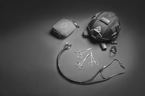 First aid kit, phonendoscope, a set of scissors with a helmet lie on a gree.. Stock Photos