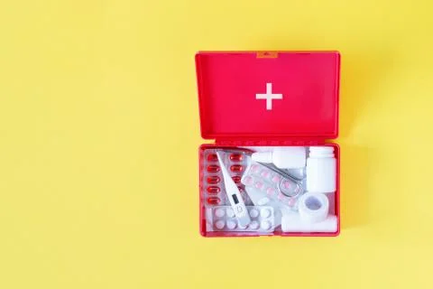 First aid kit red box with medical equipment and medications for emergency to Stock Photos