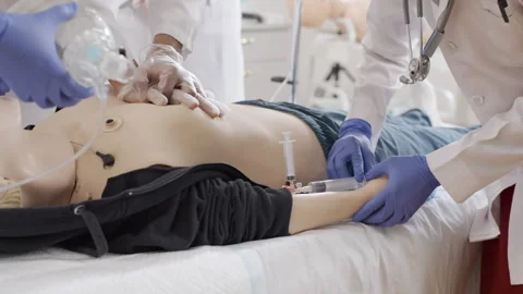 First aid training session in a clinic using a medical dummy for practice Stock Footage 281362248