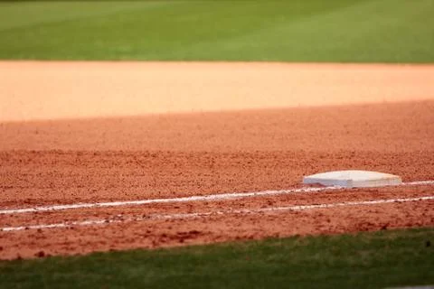 First base featured in empty baseball field Stock Photos