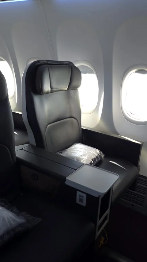 First-class airplane seat with tray table and window. Stock Footage 312517571