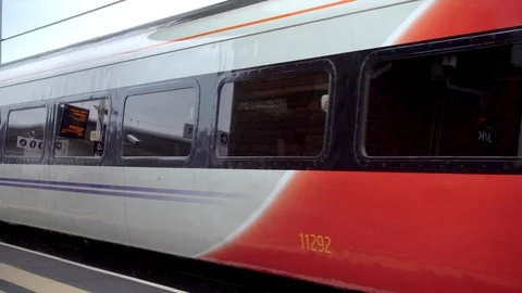 First class train carriage moving slowly along a station platform. Video stock 93929724