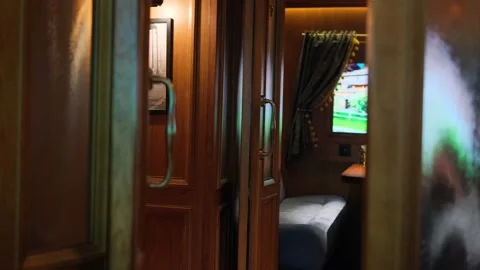 First-class vintage train compartment with wooden doors, a cozy bed, a small Stock Footage 303016122