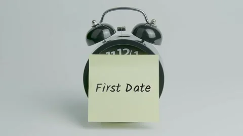 First Date Text or Word on Yellow Note Paper Sticking onto Black Alarm Clock Stock Footage 299203650