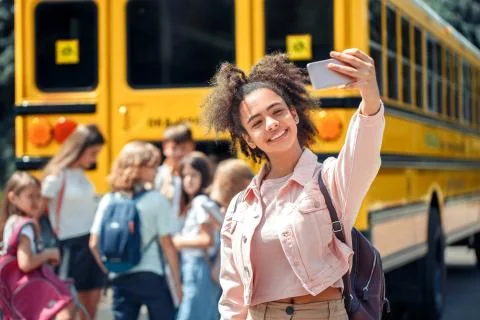 First Day. Classmates going to school by bus african girl close-up taking selfie Stock Photos