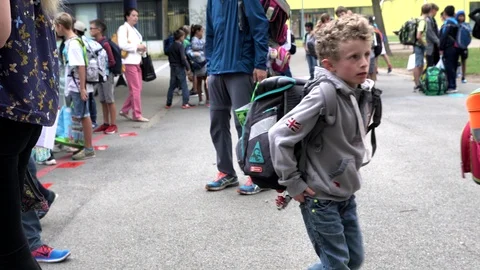 First Day Of School - elementary students in a schoolyard, waiting in line. Stock Footage 104263706