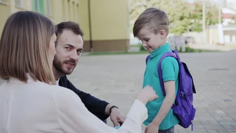 First day of school. Happy smiling young parents preparing and leading their Stock Footage 111549539