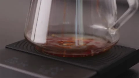 First drops of coffee falling into empty glass server Stock Footage 332720235