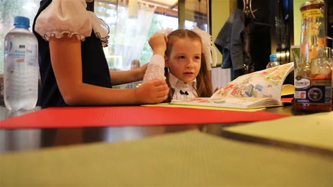 First grade pupils are goofing around at the table of the cafe Stock Footage 106098487