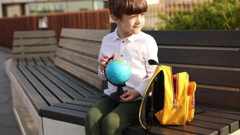 First grade school boy sits outside and opens vegetable lunch Stock Footage 245752609