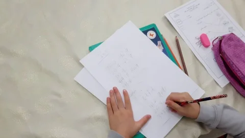 First grade school girl practicing math drills at home Stock Footage 98311856
