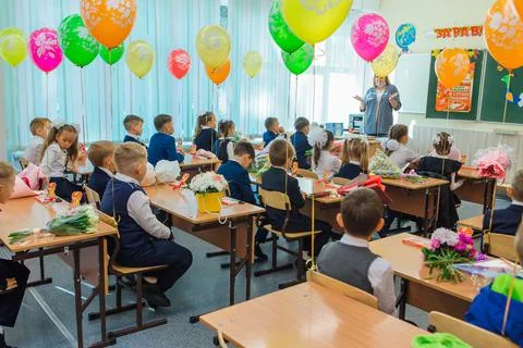 First-grade students and teacher are in school classroom at first lesson. The Stock Photos