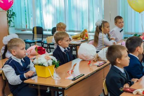 First-grade students and teacher are in school classroom at first lesson. The Stock Photos