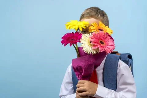 First grader with a backpack holds a bouquet of flowers 스톡 사진