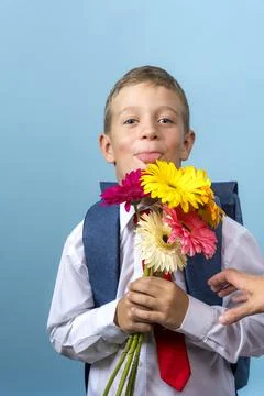First grader with a backpack holds a bouquet of flowers Stock-Fotos