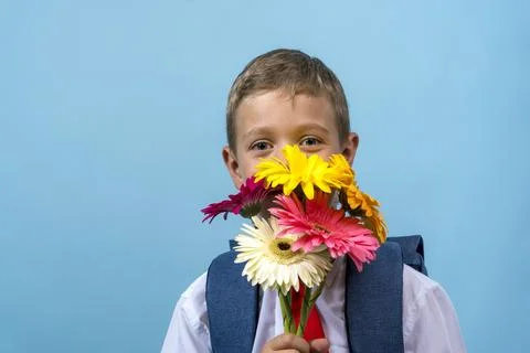 First grader with a backpack holds a bouquet of flowers Stock-Fotos