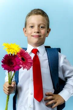 First grader with a backpack holds a bouquet of flowers 库存照片