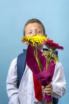 First grader with a backpack holds a bouquet of flowers Foto stock