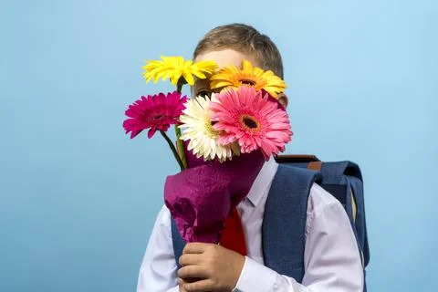 First grader with a backpack holds a bouquet of flowers Stock-Fotos