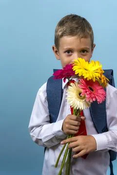 First grader with a backpack holds a bouquet of flowers Photos