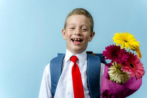 First grader with a backpack holds a bouquet of flowers Foto stock