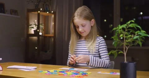 A first grader making an English word on a game card on a wooden table. Reading. Stock-Footage 301686907