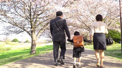 A First Grader Walking Hand in Hand with His Parents Stock Footage 331979743