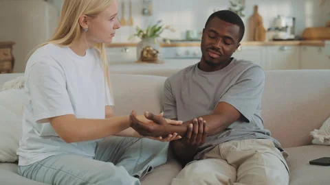 First help in case of trauma at home, wife stroking arm of husband, healthcare Vídeos de archivo 319014565