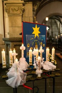 First holy communion or confirmation burning candles rowed up in church befor Stock Photos