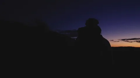 First light of day breaks over the horizon, silhouette walks toward light Video stock 127458581