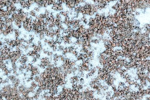 First light snow at the beginning of winter on surface of a gravel path. Symb Stock Photos
