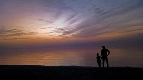 First light of the Sun silhouette  with father and his son. Stock Photos