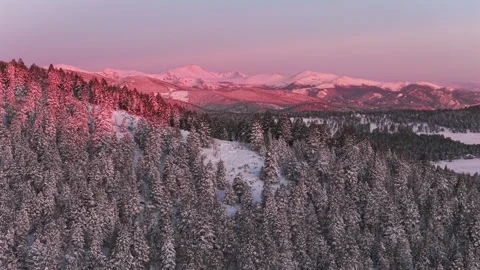 First light sunrise Purple Rocky Mountains Majesty Mount Blue Sky Evergreen Stock Footage 336274341