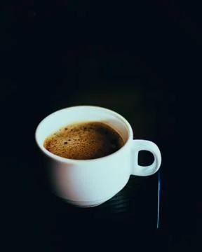 First morning cup of double shot of espresso with stirrer on dark wooden tabl Stock Photos