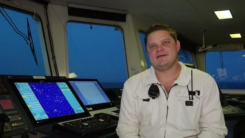 First officer in white uniform talks and smiles in cabin 動画素材 116608718