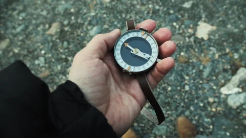 First Person Holding Compass Over Rocky Ground Stock Footage 307092298
